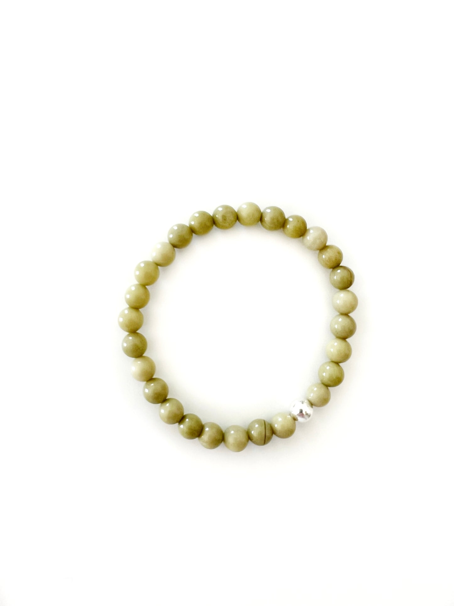 Avocado Jasper stretch bracelet with one sterling silver bead on a white background