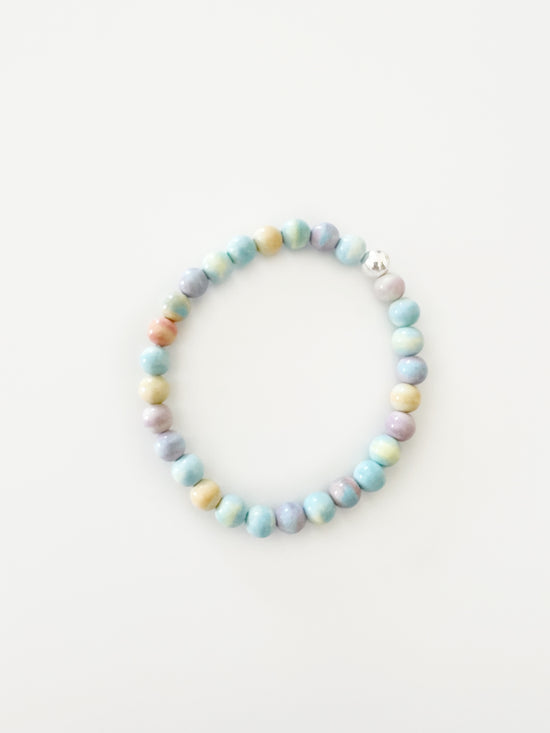 candy colored stretch bracelet with one silver bead. colors are yellow, blue, green and lilac