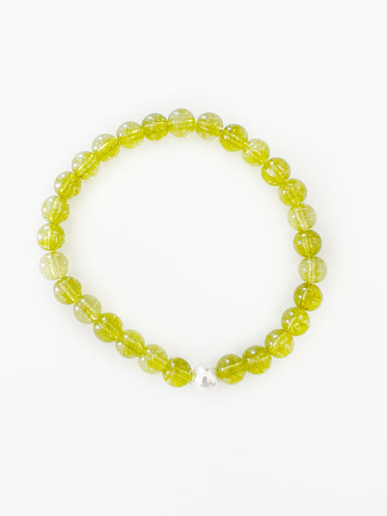  a translucent green stretch bracelet with one silver bead.