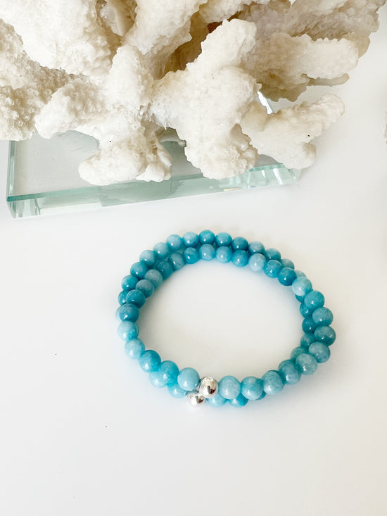 Set of two Blue Chalcedony stretch bracelets with one Sterling Silver bead with white coral behind it.