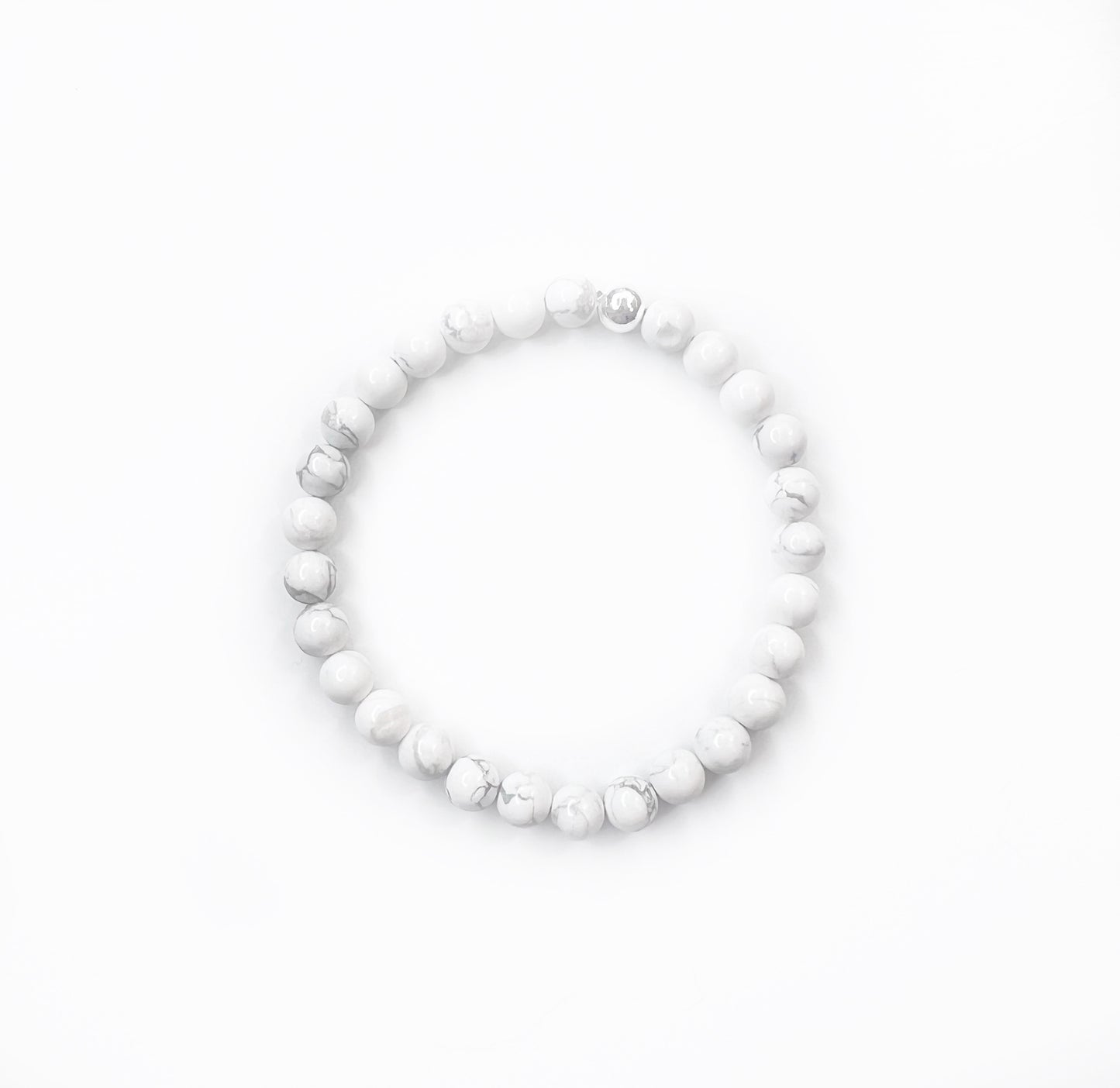 white howlite stretch bracelet with one silver bead on a white background
