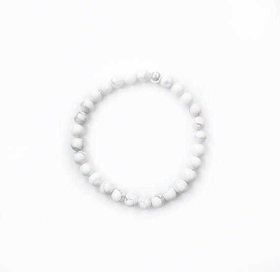 white howlite stretch bracelet with one silver bead on a white background