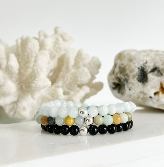 Simple modern gemstone stretch bracelet stack with Black Onyx Amazonite and Green Moonstone. Each bracelet has one Sterling Silver bead on it.