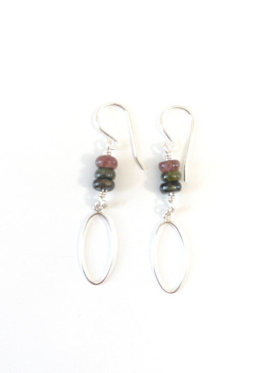 a pair of earrings with three Tourmaline rondelle beads on top of each other with a long flat sterling oval hanging from the bottom. They are on a white background.
