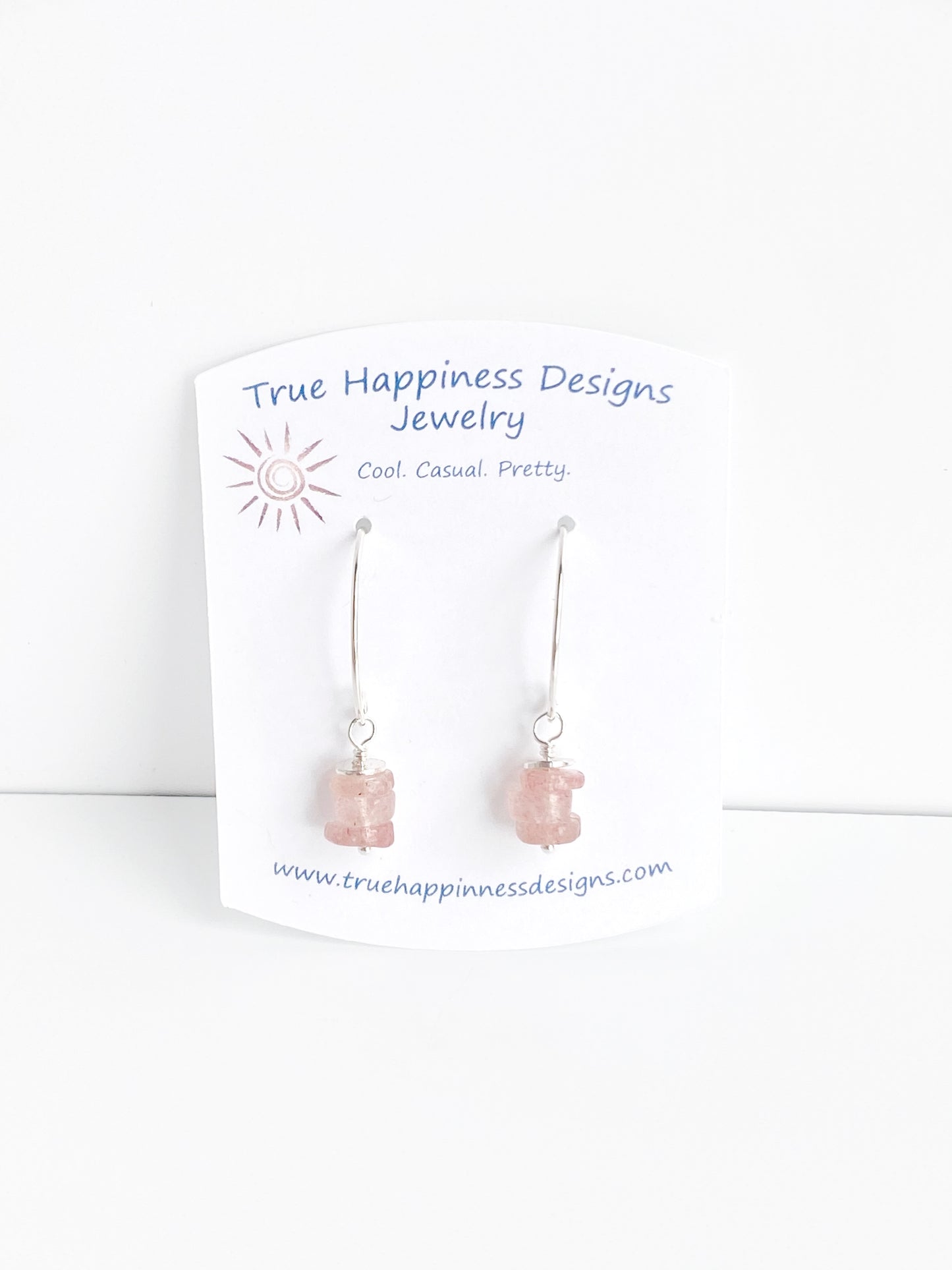 handmade strawberry quartz earrings hung on a true happiness designs earring card.